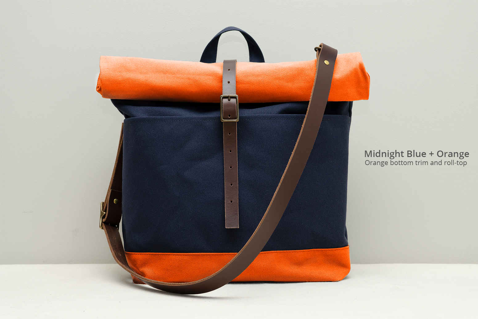 https://www.moderncoup.com/wp-content/uploads/2022/05/moderncoup-roll-top-bag-hero-custom-blue-orange_1055x1034.jpg